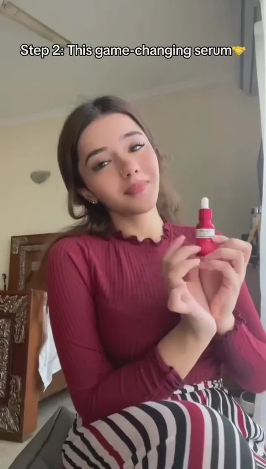 A creator holding a red MoraGlame serum, captioned “Step 2: This game-changing serum”